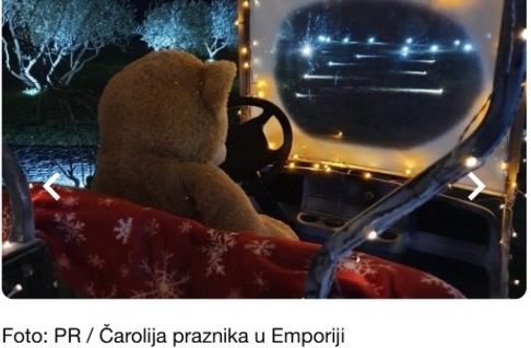 A festively dressed teddy bear rides through the lantern-lit vineyard on a golf cart