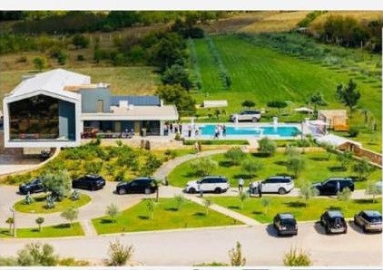 Aerial view of the Imperial Vineyards estate with Range Rover vehicles gathered among the vines and pool terrace