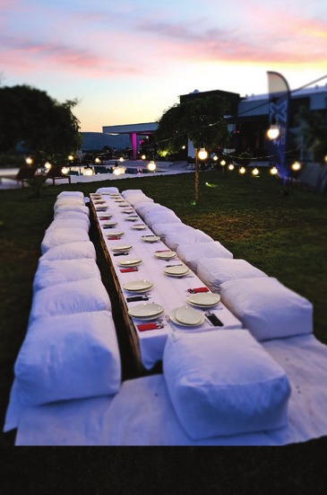A long banquet table set for a summer evening at the estate, lit by string lights, as submitted for National Geographic Traveller's September 2024 UK edition